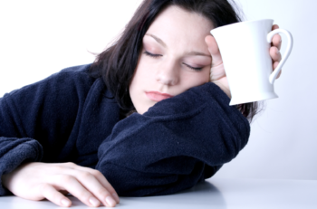 a woman with a coffee cup tries to wake up after a sleepless night